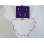 A set of matching silver necklace and bracelet.