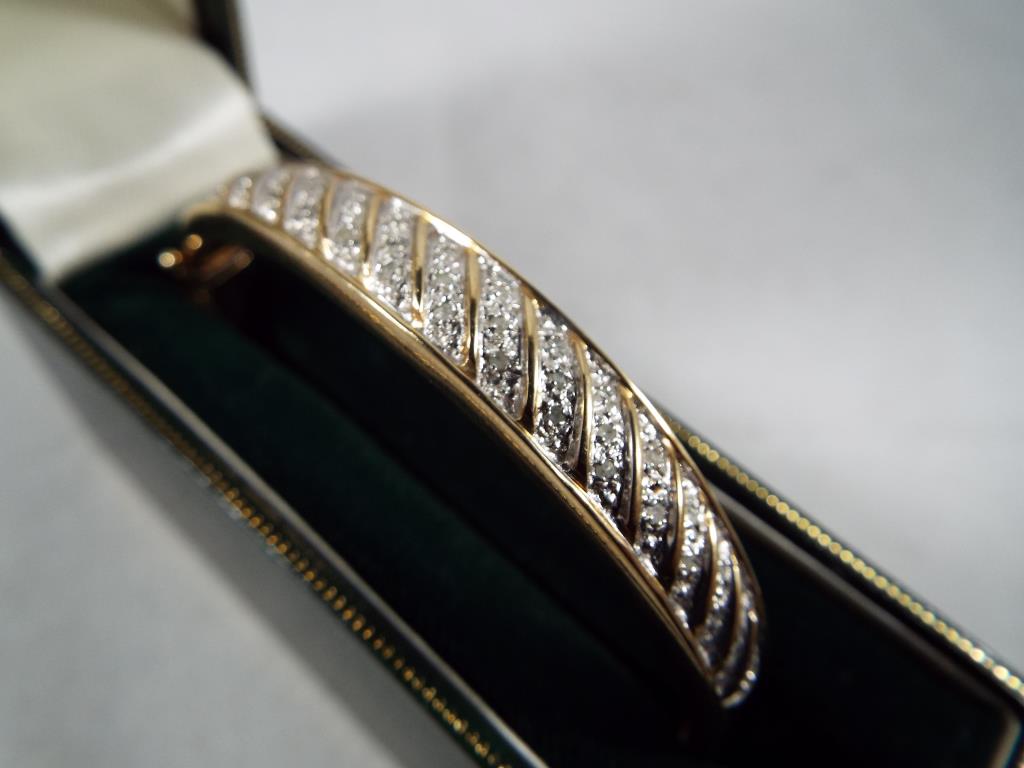 A lady's hallmarked 9ct gold torque bracelet, with stone set detailing, approx weight 15. - Image 2 of 2