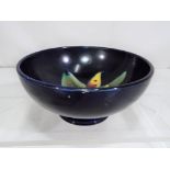 Moorcroft Pottery - A small Moorcroft pottery footed bowl decorated with orchids on a blue ground,