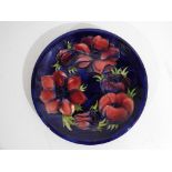 Moorcroft Pottery - a large Moorcroft Pottery plate decorated with anemone on a blue ground