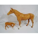 A lot comprising of two Beswick Palomino horses, largest approximately 29 cm tall, Est £40 -£60.