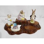 Beswick - a Beswick ceramic tree trunk stand with four Beatrix Potter figurines to include Mr