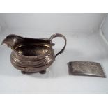 A George V silver hallmarked card case Birmingham assay 1914 and a silver hallmarked cream jug