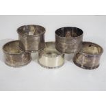 Three silver hallmarked heavy napkin rings and a further two silver plated, various assay marks.