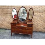 A late Victorian mahogany dressing table having three oval mirror plates to the back with twin