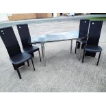 A chrome and black glass dining table with four faux leather chairs approx 75cm x 140cm x 80cm,