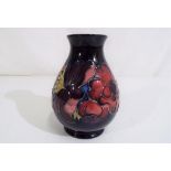 Moorcroft Pottery - a Moorcroft Pottery vase decorated with anemone on a blue ground impressed