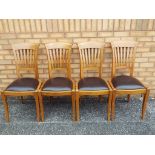 Four solid wood dining chairs with leather seats