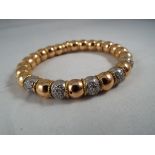A lady's 18ct gold expanding bangle with five stone set links stamped 750 Italy, approx weight 52.