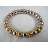 A lady's 18ct white and yellow gold expanding bangle with five stone set links, stamped 750 Italy,