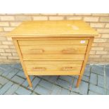 A light wood chest of two drawers,