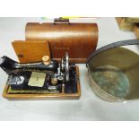 A decorative vintage Singer sewing machine in a wooden case and a vintage jam pan
