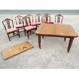 A good mahogany extending dining table on turned supports terminating in castors,