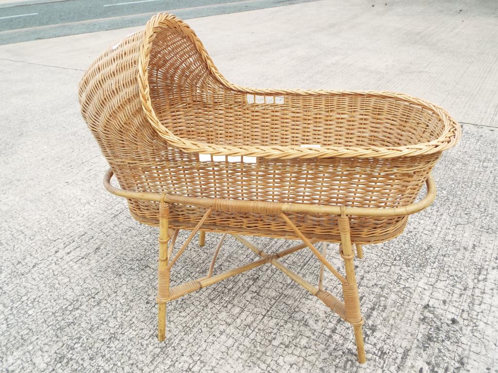 A child's wicker crib on bamboo stand