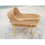 A child's wicker crib on bamboo stand