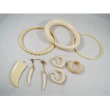 A collections of jewellery to contain three bone bangles one in the form of a snake, pendant, ring,