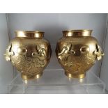 A pair of brass Asian vases with relief decoration depicting Foo dragons, approximate height 15 cm,