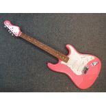 An Encore electric guitar in pink contained in carry case.