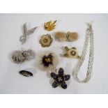 Eight vintage brooches and a white metal evening necklace,