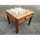 A light wood table with twin drawers, the table inset with marble chess board,