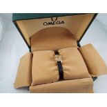 Omega - a lady's yellow metal cased wristwatch, Swiss movement, black leather strap,