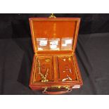 A good quality jewellery box containing a collection of pin badges,