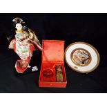 A figurine in the form of a geisha girl set on a plinth, approx 32cm (h),