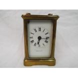 A brass carriage clock, Roman numerals to a white dial, movement marked 'R & Co Made in Paris',