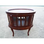 A good quality glazed oval drinks cabinet with removable serving tray and carved decoration,