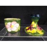 Moorcroft - a Moorcroft Pottery dwarf candlestick decorated with hibiscus on a green ground,