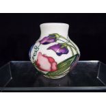 Moorcroft - a Moorcroft sweet pea vase, approximate height 8 cm.