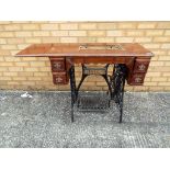 A cast iron and wooden sewing machine table with extending flap (lacking machine) approx 74 x 87 x
