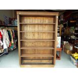 A large pine bookcase with five shelves,