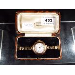 A lady's wristwatch with ceramic dial and rolled gold strap, dial approximately 1.