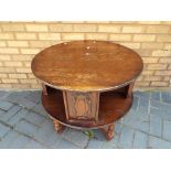 A circular occasional table/book case, approximately 63 cm [h] and 76 cm [d].
