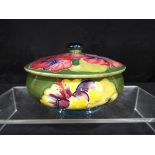 Moorcroft - a Moorcroft Pottery lidded bowl decorated with hibiscus on a green ground,