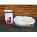 A wicker Moses basket sealed in original packaging with a Phil & Teds cocoon carry cot and buggy