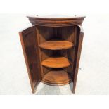 A good quality oak corner cabinet with twin doors containing two shelves,
