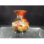 Moorcroft - a Moorcroft Pottery bulbous vase with flared rim decorated with orchid on a flambe