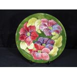 Moorcroft - a large Moorcroft Pottery plate decorated with clematis on a green ground,