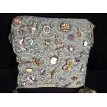 A cushion with a quantity of costume jewellery brooches.