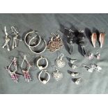 Ten pairs of silver earrings.