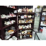33 novelty ceramic teapots displayed over five shelves to include traditional telephone box,