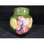 Moorcroft - a Moorcroft Pottery lidded ginger jar decorated with hibiscus on a green ground,