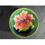 Moorcroft - a small Moorcroft Pottery footed bowl decorated with hibiscus on a green ground,