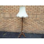 Ercol - a mid-elm Ercol standard lamp with neutral coloured shade bearing Ercol stamp to the foot,