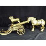 Three brass ornaments, one depicting a cannon,