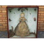 A Victorian wax head doll with brown glass eyes and painted eyebrows (wax is peeling from head