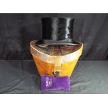 William Wadham - An antique leather top hat box with fitted interior with silk top hat by William