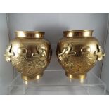 A pair of brass Asian vases with relief